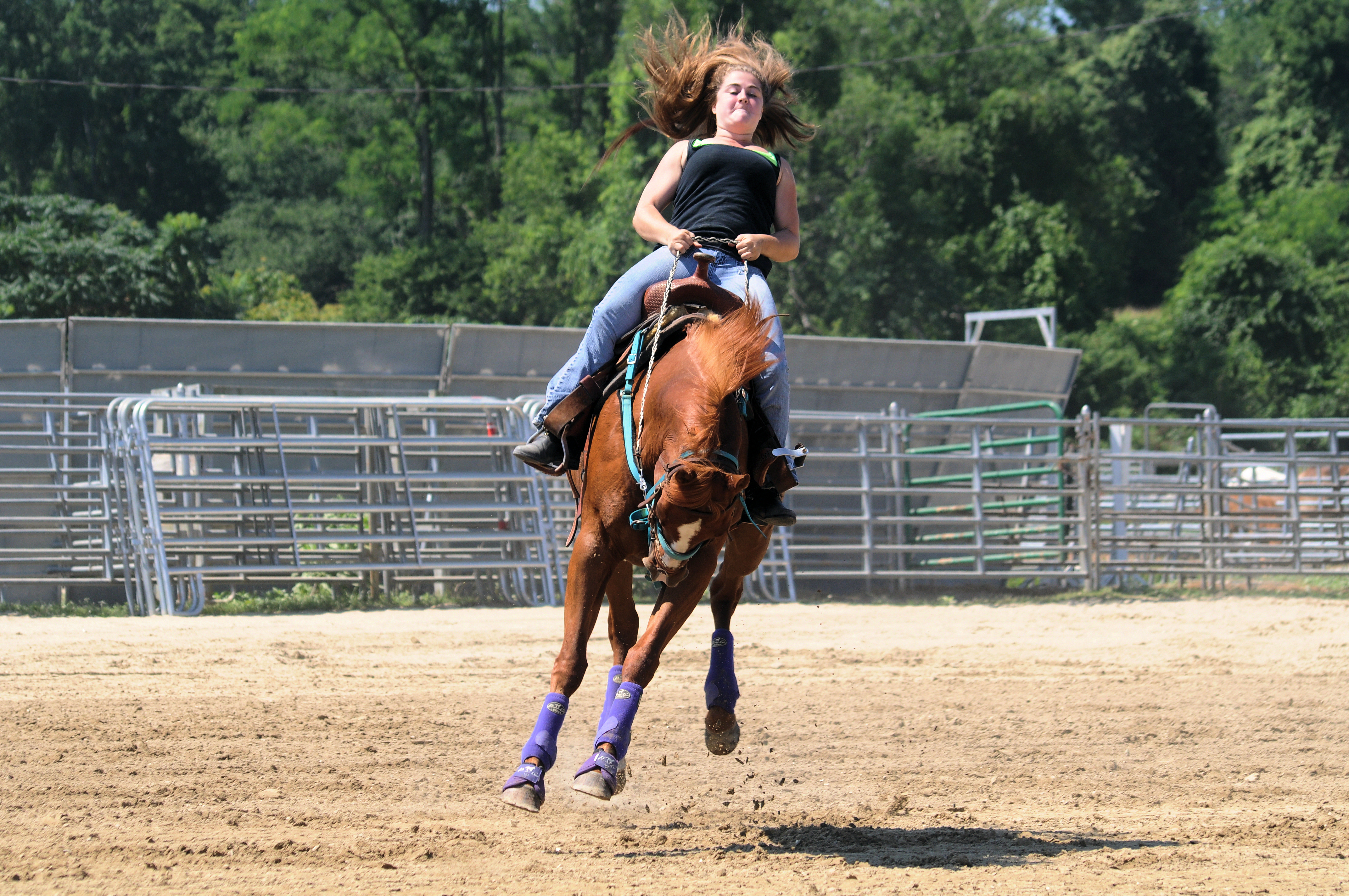 A woman riding around a track on a horse